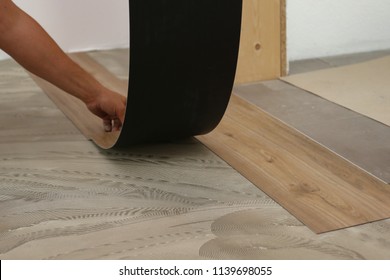 Worker Installing New Vinyl Tile Floor