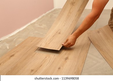 Worker Installing New Vinyl Tile Floor