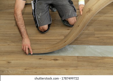 The Worker Installing New Vinyl Tile Floor