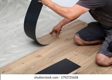 The Worker Installing New Vinyl Tile Floor