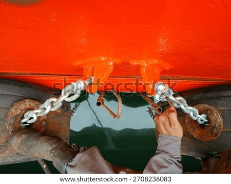 Worker Installing Omega Chain on Ship Fender After Bulwark Painting