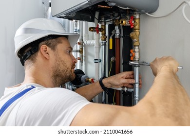 worker installing pipes of house gas heating boiler
