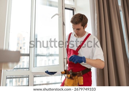Worker installing plastic window indoors, closeup view