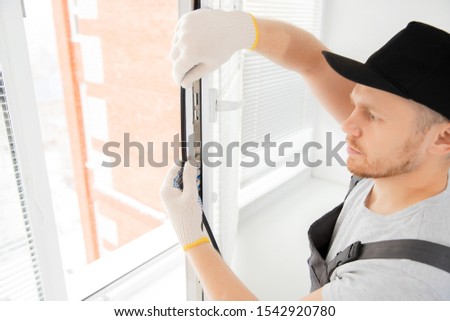 Worker in installing rubber seals on plastic upvc window.
