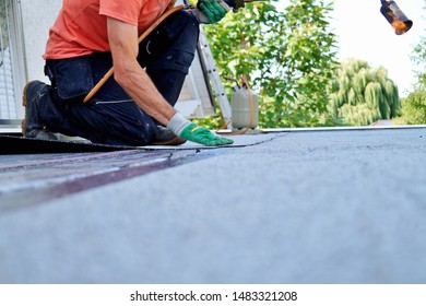 worker installing tar foil on the rooftop of building. Flat roof installation. Waterproof system by gas and fire torching. Roofing felt. Roofer working. Roofer working tool. Waterproofing - Shutterstock ID 1483321208