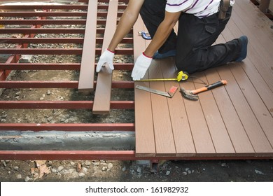 Worker Installing Wood Floor For Patio