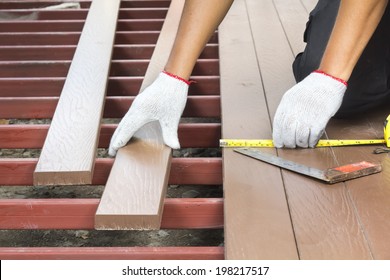 Worker Installing Wood Floor For Patio