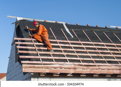 Worker installs bearing laths on the truss system - Shutterstock ID 334104974