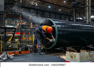 Worker installs clamping ring on coated pipe	