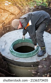 A Worker Installs A Manhole On A Septic Tank. Conducting Communications In A Residential Building.