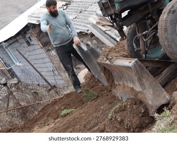 Worker instructing tractor operator to place water tank