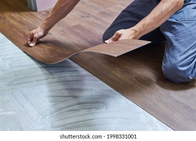 worker joining vinyl floor covering at home renovation - Shutterstock ID 1998331001