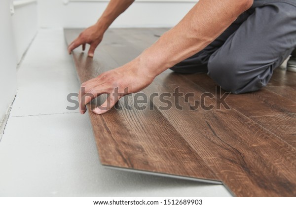 worker\
joining vinyl floor covering at home\
renovation