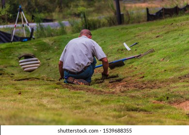 A Worker With A Landscaping Crew Sits To Lay New Saint Augustine Sod Grass On A Job Site