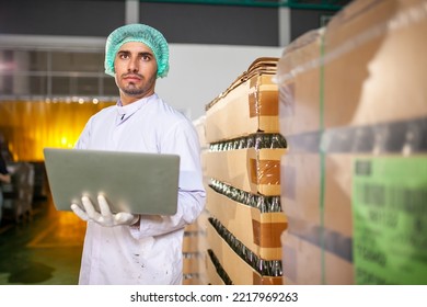 Worker With Laptop Is Checking Product On The Production Line In The Beverage Factory. Manufacturer Checks Quality Of Food Industry.