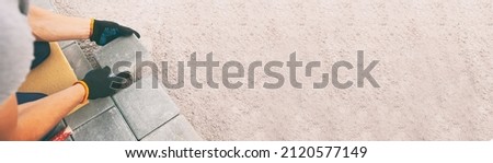 Worker lining paving slabs path