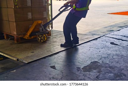 Worker loading and unloading shipment carton boxes and goods on wooden pallet by forklift  from container truck to warehouse cargo storage in logistics and transportation industrial 