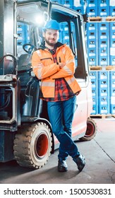 Worker In Logistics Distribution Center Leaning Against His Forklift