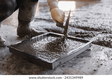 Worker making cube concrete casting by steel mould for control quality cement in building site.