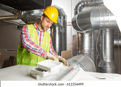 Worker making final touches to HVAC system. HVAC system stands for heating, ventilation and air conditioning technology. Team work, HVAC, indoor environmental comfort concept photo.