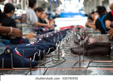 worker making shoe in production line of footwear industry