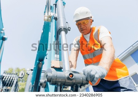 Worker man chek pipe system of hydraulic hose valves in industry machinery.