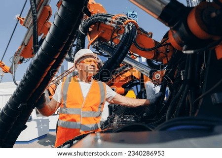 Worker man chek pipe system of hydraulic hose valves in industry machinery. Foto stock © 