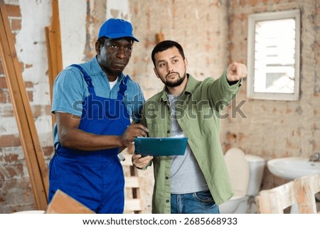 Worker man is clarifying details of work from foreman
