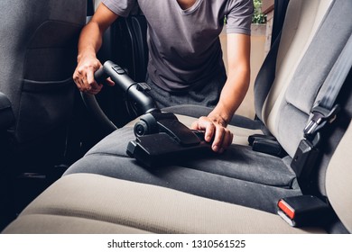 Worker man cleaning dust interior vacuum inside car - Shutterstock ID 1310561525