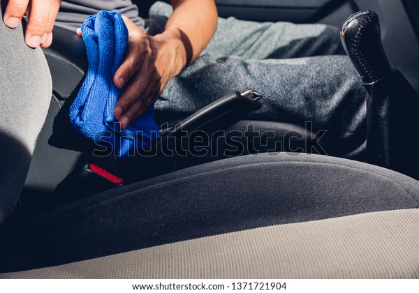 Worker man cleaning dust interior by cloth\
microfiber inside car after\
wash