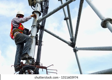Worker man climb for working on telecom tower,High working area,Engineer wear safety equipment. Blue sky background.