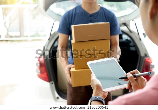 worker man delivery the boxs to woman home or office\
, with tablet for sign