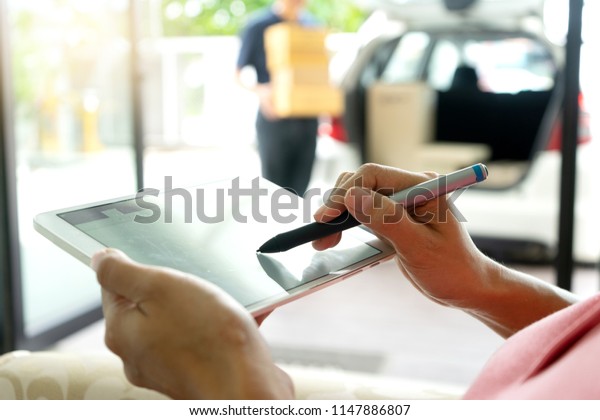 worker man delivery the boxs to woman home or office
, with tablet for sign