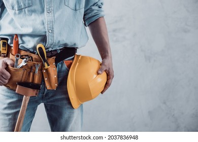 Worker Man Holding Construction Helmet Tool Near Concrete Or Cement Wall. Male Hand And Hard Hat For House Room Renovation. Home Renovation Concept