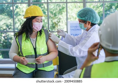 Worker Man Sitting To Getting Covid Vaccine, With Nurse Injecting Vaccine To Get Immunity For Protect Virus. Vaccination For Essential Workers In Clinic Healthcare At Industrial Factory.