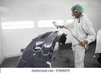 worker man spray painting on car body part in car maintenance service paint room - Powered by Shutterstock