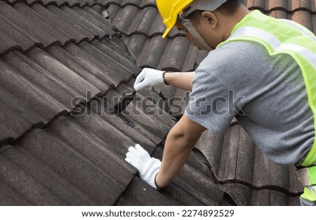 Worker man using waterproof roof coating repair to fix crack of the old tile roof. Сток-фото © 
