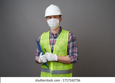 Worker Man Wearing Face Mask And Protective Hard Hat. Young Engineer Worker Wear A White Helmet And Medical Mask. Coronavirus Hygiene, Safety Concept