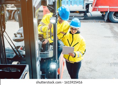 Worker And Manager At Distribution Center Behind A Forklift