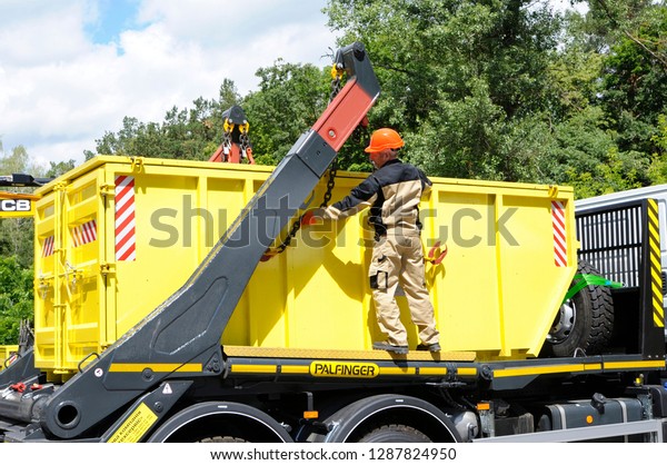 Worker managing crane of a truck and radioactive waste\
storage container loaded. October 1, 2018. State corporation\
“Radon”. Kiev, Ukraine 