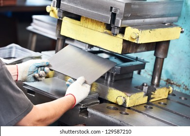 worker at manufacture workshop operating metal press machine - Powered by Shutterstock