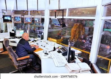 Worker In Manufacturing Plant At Machine Control Panel