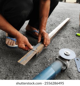 Worker marking a hole on a metal surface with a pen, with a cutting machine or grinder - Powered by Shutterstock