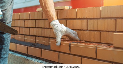 Worker Or Mason Hands Laying Bricks Close Up. Bricklayer Works At Brick Row. Brickwork On Construction Site