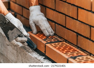 Worker Or Mason Hands Laying Bricks Close Up. Bricklayer Works At Brick Row. Brickwork On Construction Site