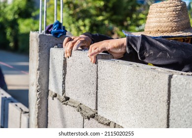 Worker masonry are building walls with cement blocks and mortar by building up in layers.