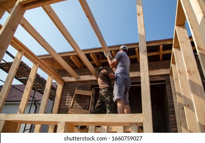 A Worker Measures A Wooden Workpiece With A Meter. Building A House.