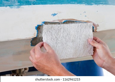 A Worker Is Measuring A Fiberglass Sheet To Repair A Boat