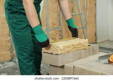 Worker Measuring Thermal Insulation Material Indoors, Closeup