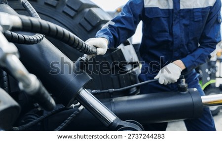 Worker mechanic Diagnostics pipe system of hydraulic hose valves in industry machinery truck.
